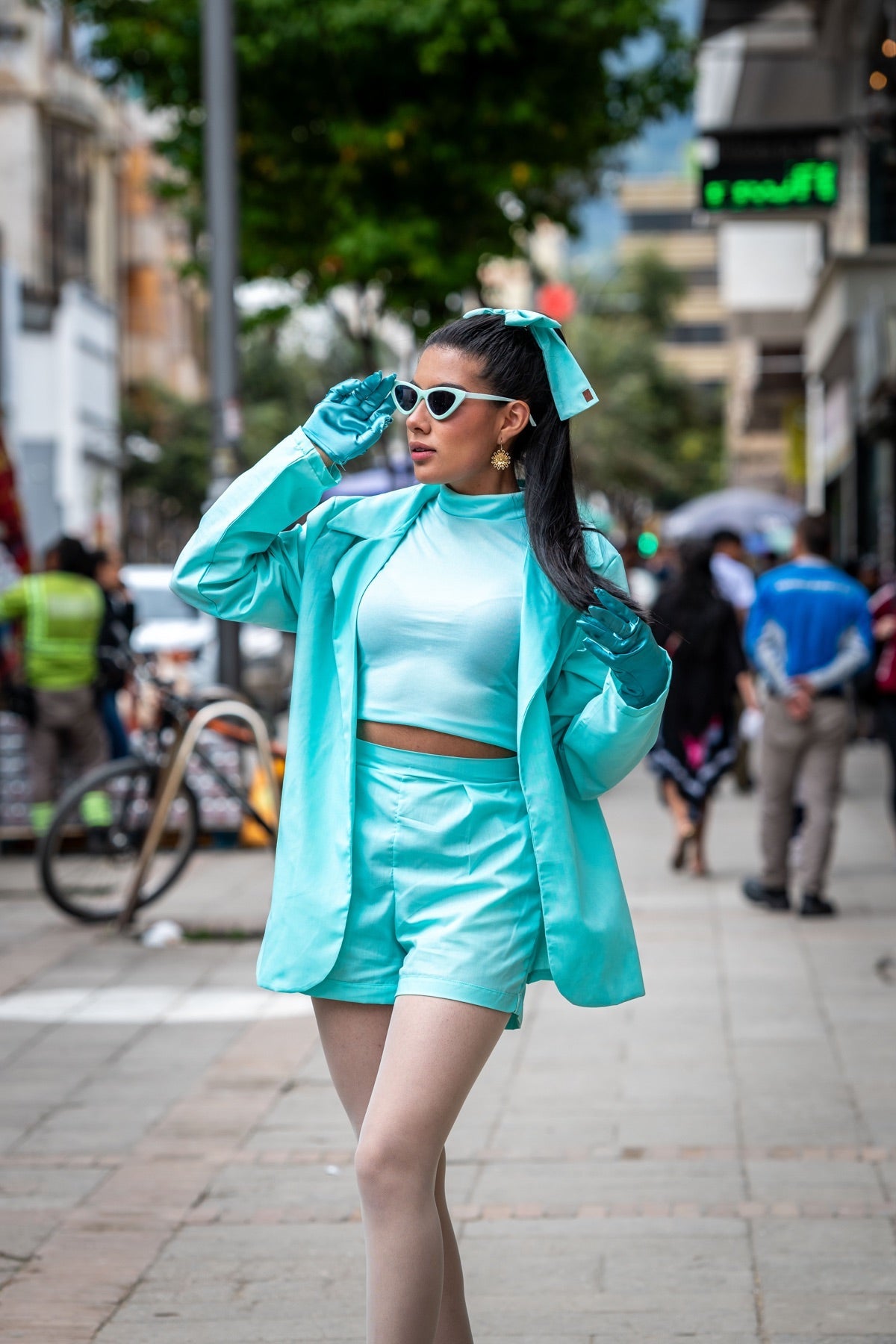 Modelo con conjunto turquesa y moño de Carolina González en una calle de Duitama